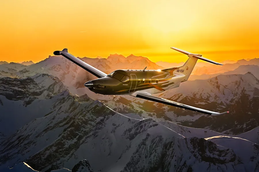 Pilatus PC-12 PRO im Flug über verschneiten Bergen im Abendlicht, eines der Flugzeuge mit Garmin Autoland